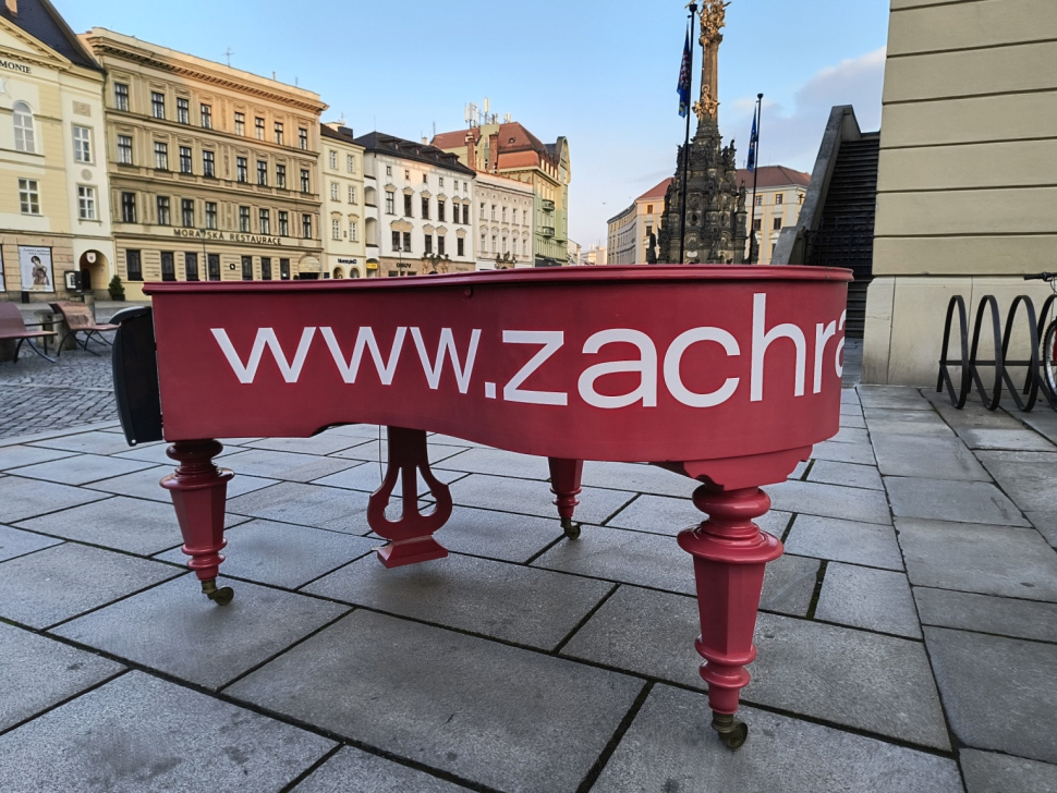 Za červenými piany v ulicích Olomouce stojí filharmonici